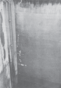 Close-up view of boot-topping (right) on a VLCC after five years of exposure. Note the smooth, corrosion-free surface. The boot-topping is immersed, except when the ship is light (without cargo or ballast). Note severe abrasion from dock bumpers (left).